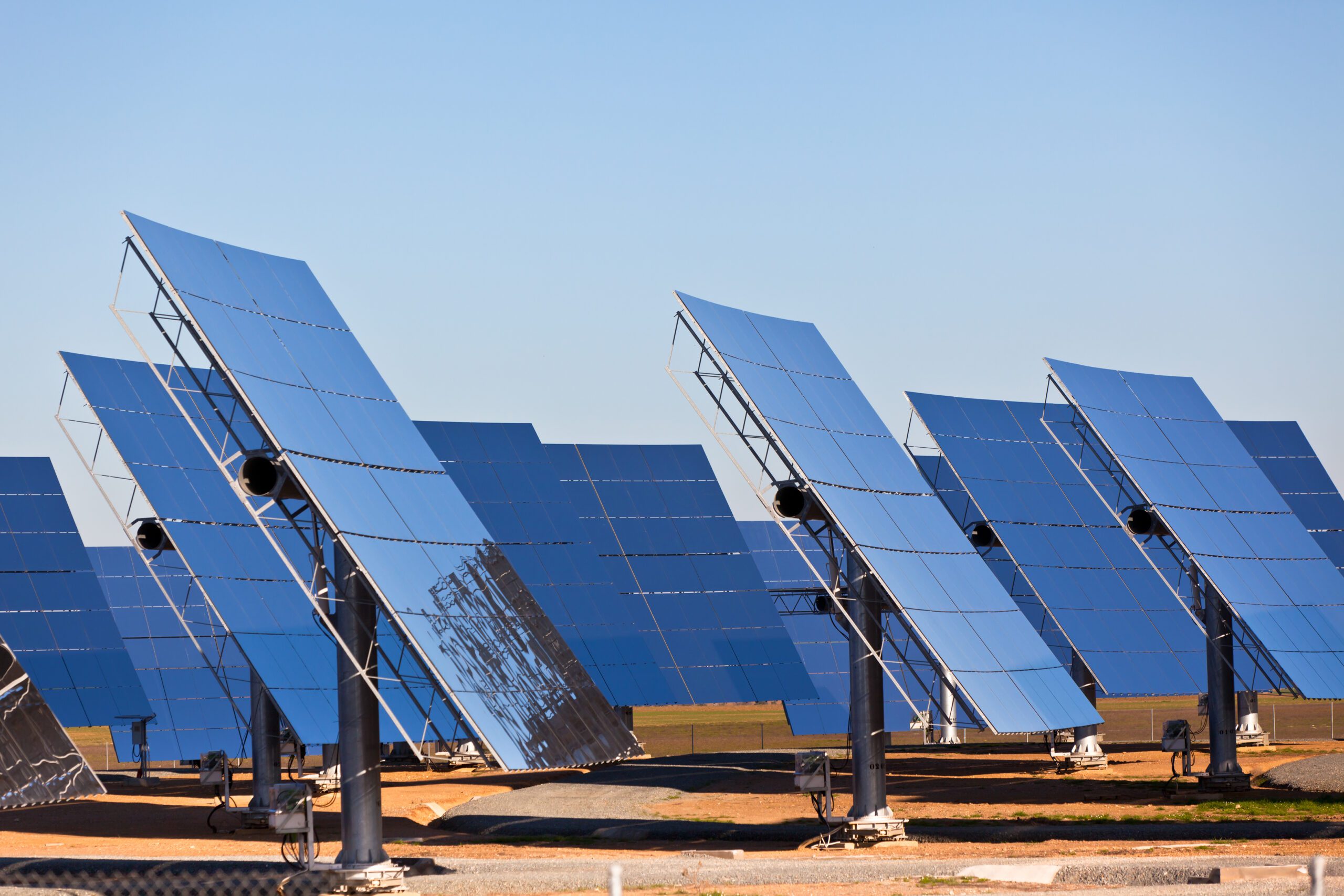 Ground Solar Panel Installation in DFW - LBJ Roofing Company Corp. Ground-mounted solar panels angled toward the sun under clear skies